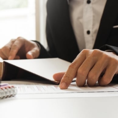 Photographie illustrant une personne qui vérifie la conformité réglementaire d'un document